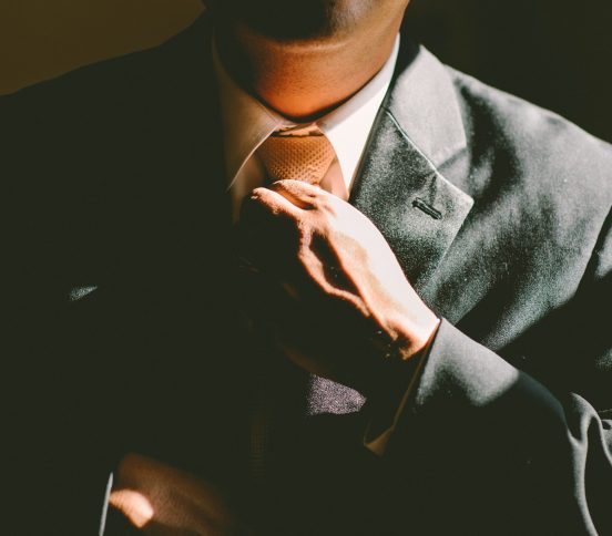 Man in a suit adjusting his tie
