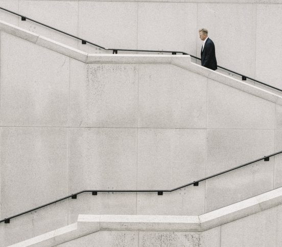 Man in a suit walking up staircase